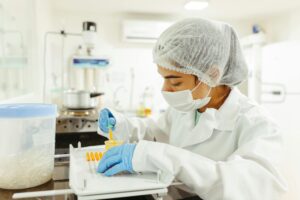 A scientist wearing protective gear performs a meticulous experiment in a laboratory setting.